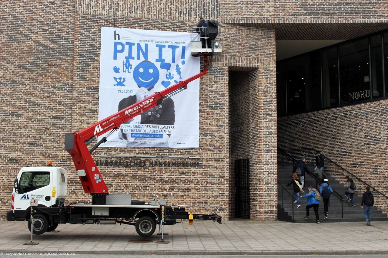 Pin-it! Ophangen van spandoek aan gevel van Europäisches Hansemuseum in Lübeck. Foto Sarah Niesel