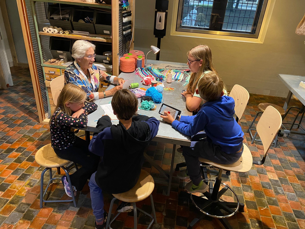 Vrijwilliger Corrie met kinderen in WERKPLAATS.png